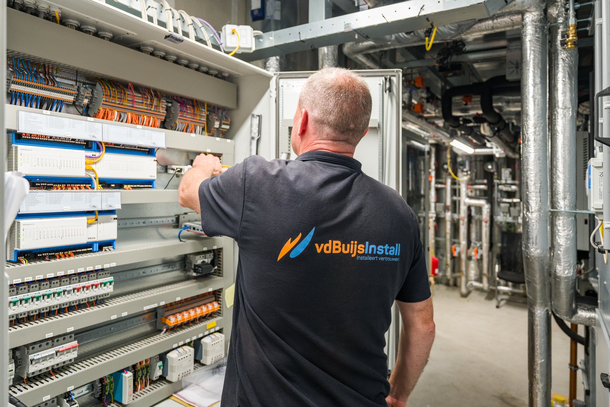 Servicemonteur verricht onderhoud aan installatie bedrijfspand
